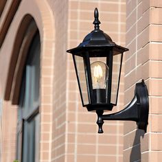 an old fashioned street light on the side of a building