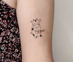 a small cow tattoo on the left inner arm and lower arm, with an arrow in it's right side