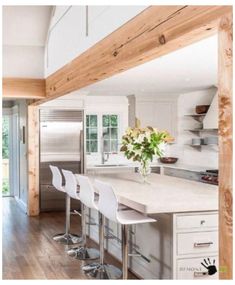 a kitchen with white counter tops and wooden floors