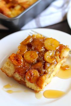 a piece of bread pudding with bananas on top and caramel sauce drizzled over it