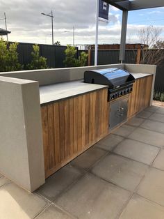 an outdoor kitchen with grill and counter top