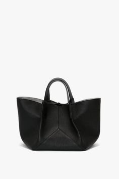 With its grainy calf leather body and smooth leather handles, the W11 Mini Tote embodies the house’s luxurious sophistication. With top handles and a long strap, it can be worn either as a crossbody bag or handheld. Leather ties are functional and decorative, ensuring the bag can be closed securely and items stored safely. The house’s signature stitched leather V-shaped panels add decorative interest, while suede lining adds a sumptuous finishing touch. Victoria Beckham W11 Mini Tote In Black Le Top Handle Shoulder Bag In Pebbled Leather, Pebbled Leather Top Handle Shoulder Bag, Workwear Shoulder Bag With Detachable Handle In Pebbled Leather, Pebbled Leather Satchel Shoulder Bag With Handles, Pebbled Leather Satchel Shoulder Bag, Luxury Pebbled Leather Shoulder Bag With Handles, Pebbled Leather Top Handle Bag For Work, Pebbled Leather Satchel Bag With Handles, Pebbled Leather Satchel With Double Top Handles