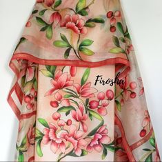 a pink and green floral print scarf with red trims on the bottom half of it