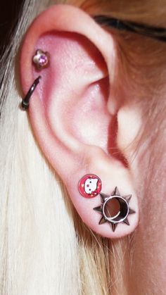 an ear with two piercings attached to it's ears and one has a star