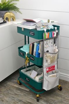 a green cart filled with lots of office supplies