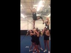 a group of women standing on top of each other in front of a gym floor