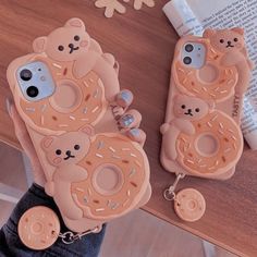 two phone cases with donuts and bears on them, one is holding the other