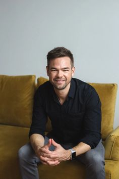 a man sitting on top of a yellow couch