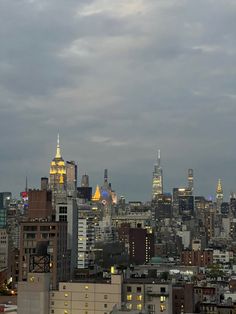 the city skyline is lit up at night, with skyscrapers in the foreground