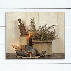 a candle is lit next to some pots and pans with plants in them on a wooden table