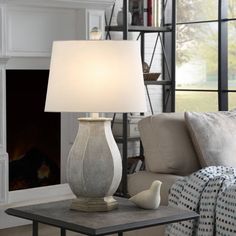 a lamp that is sitting on a table in front of a fire place and couch