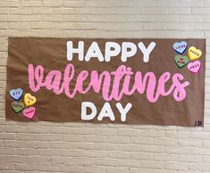 a sign that says happy valentine's day on a brick wall with lots of hearts