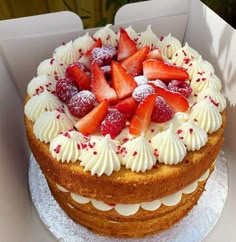 a cake with white frosting and strawberries on top