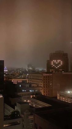 the city skyline is lit up at night, with buildings and skyscrapers in the background