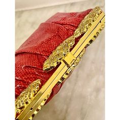 Well constructed water snake clutch in the spirit of Judith Leiber. Pleated snakeskin on a quality gold metal frame. Three crystal encrusted rosettes adorn the top. Immaculate interior. Circa 1980s. Luxury Gold Clutch For Gala, Luxury Red Evening Bag For Formal Occasions, Designer Gold Evening Bag For Gala, Luxury Red Clutch For Evening, Designer Gold Clutch For Gala, Luxury Red Clutch With Gold-tone Hardware, Luxury Red Evening Bag, Red Clutch With Gold-tone Hardware For Evening, Elegant Red Clutch With Gold-tone Hardware