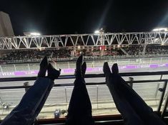 two people's feet in the air at an indoor track with lights on them