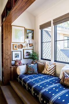 a living room filled with lots of furniture and pictures on the wall next to a window