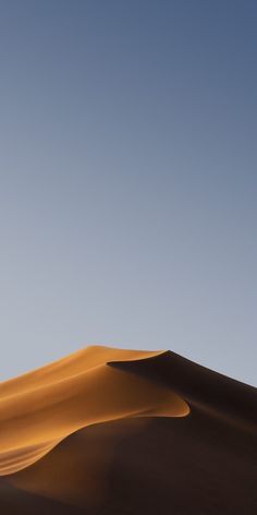 an image of a desert landscape with sand dunes and blue sky in the background at sunset