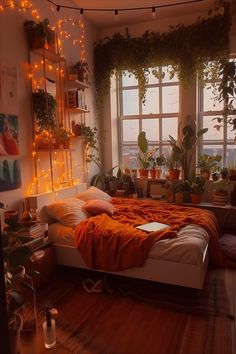 an aesthetic orange warm boho bedroom. orange throw blanket on bed with a MacBook, plants everywhere, hanging fairy lights, surrounded by plants, high rise apartment, cozy earthy themed room Fall Bedroom Decor, Interior Design Per La Casa