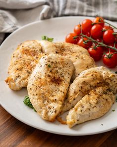 some chicken and tomatoes on a white plate