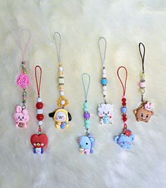 four different key chains with cartoon characters hanging from them on a white furnishing