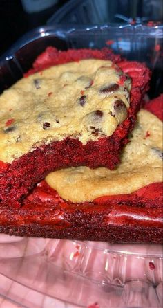 two red velvet desserts sitting on top of a plastic container filled with chocolate chip cookies