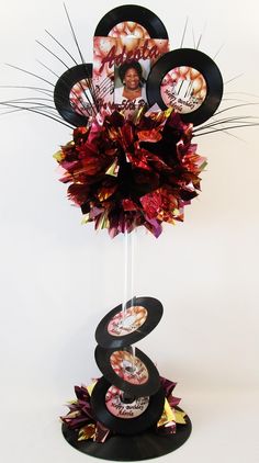 there is a cake stand made out of record's and flowers on top of it