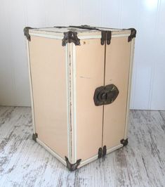 an old suitcase sitting on top of a wooden floor next to a white painted wall