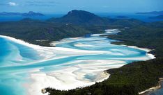 an aerial view of white sand and blue water