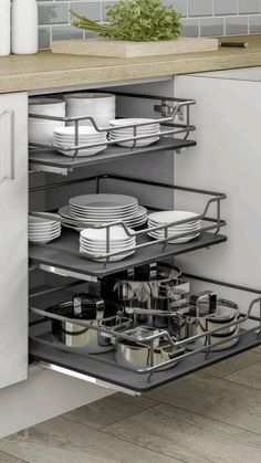 an open drawer in a kitchen filled with dishes