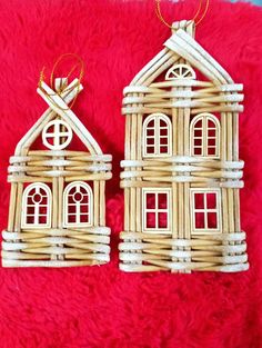 two small houses made out of wicker sitting on a red blanket