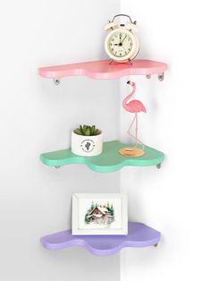 three shelves with two different colored shelves and a pink flamingo clock on one shelf