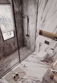 a bathroom with marble walls and flooring is shown in this image, there are two towels on the floor next to the shower