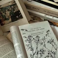 an open book sitting on top of a pile of books