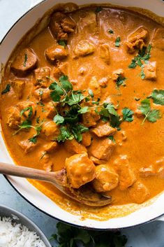 a pan filled with meat and vegetables covered in gravy, garnished with cilantro