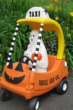 an orange toy car with a white cat in it and a taxi sign on top