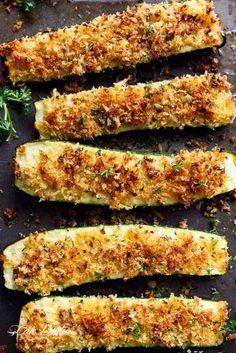 zucchini stuffed with parmesan cheese and herbs on a baking sheet, ready to be eaten