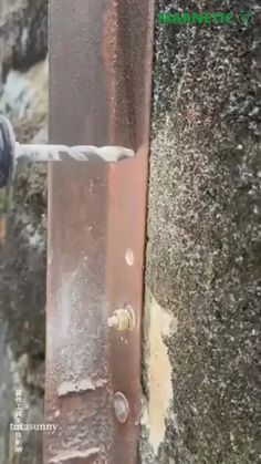 a drill that is on the side of a metal pole with water coming out of it