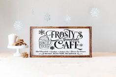 there is a sign that says frosty's special cafe on the table next to some cookies