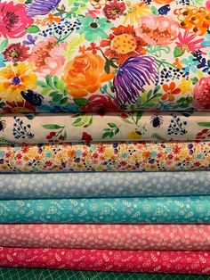 a stack of colorful fabric with flowers on them