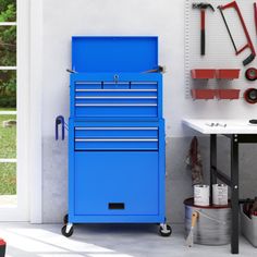 a blue tool cabinet sitting next to a white table