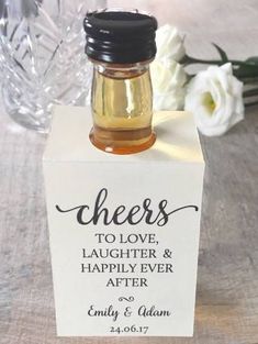 a small bottle filled with honey sitting on top of a table next to white flowers