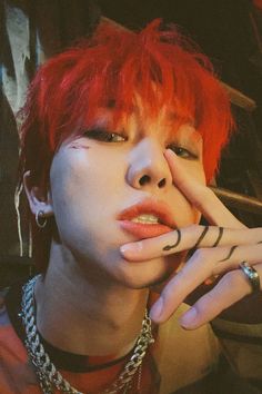 a person with red hair and piercings on their fingers