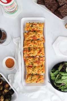 food is laid out on a table with plates and bowls