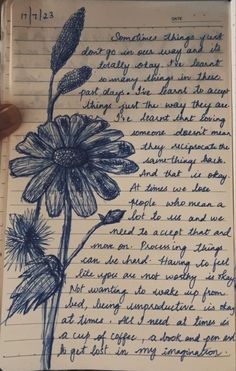 an open notebook with writing on it and a drawing of a flower in the middle