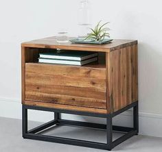 a wooden nightstand with two drawers and a plant on top