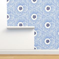 a blue and white wallpaper with an abstract flower design on the bottom half of it