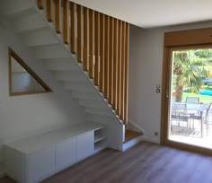 an empty living room with stairs leading to the patio