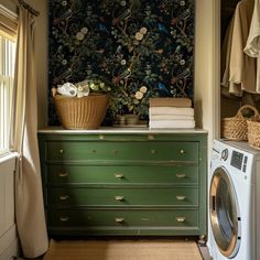 a washer and dryer are in front of a wall papered with flowers