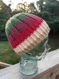 a knitted hat sitting on top of a wooden head mannequin's head